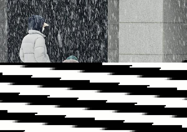 A child sweeps off snow in Chuncheon, Gangwon Province, on Dec. 30, 2023. The state weather agency issued a heavy snow advisory for parts of the capital and surrounding areas earlier in the day. (Yonhap)