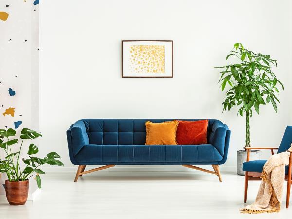 The mid-century modern sofa is characterised by sleek, rectangular shapes with shallow tufted cushions and wooden legs.