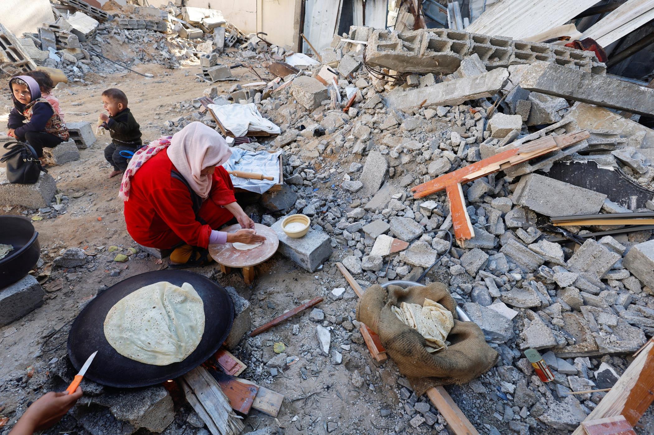 Palestinians bake bread near the ruins of houses destroyed in Israeli strikes in Khan Younis, southern Gaza Strip, palestine, Nov. 30, 2023. (Reuters Photo)