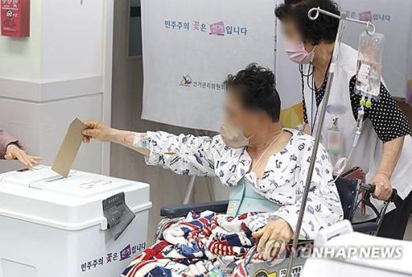 A patient casts a ballot at a polling station for the general elections in the southeastern city of Daegu on April 5, 2024. (Yonhap)