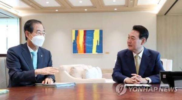 This undated file photo shows President Yoon Suk Yeol (R) meeting with Prime Minister Han Duck-soo at the presidential office in Seoul. (Yonhap)