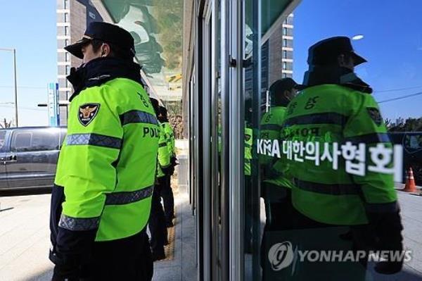 Police officers stand at the Korea Medical Association building during a police raid over trainee doctors' strike on March 1, 2024. (Yonhap)