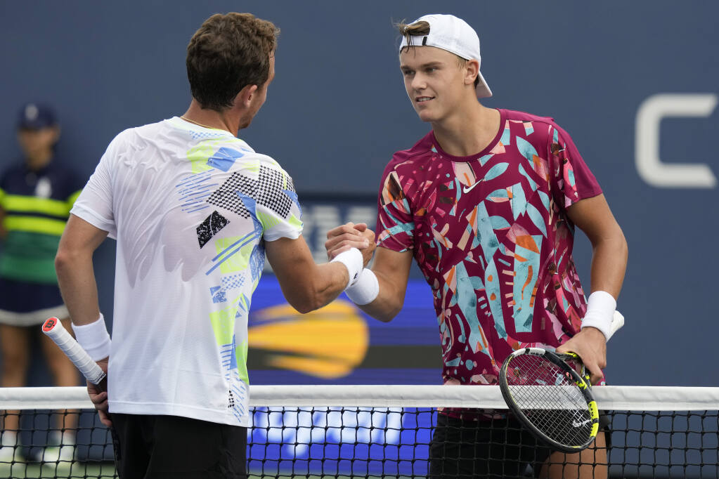 Holger Rune, of Denmark, shakes hands with Roberto Carballes Baena, of Spain, after losing their match in the first round of the U.S. Open tennis championships, Monday, Aug. 28, 2023, in New York. (AP Photo/John Minchillo)