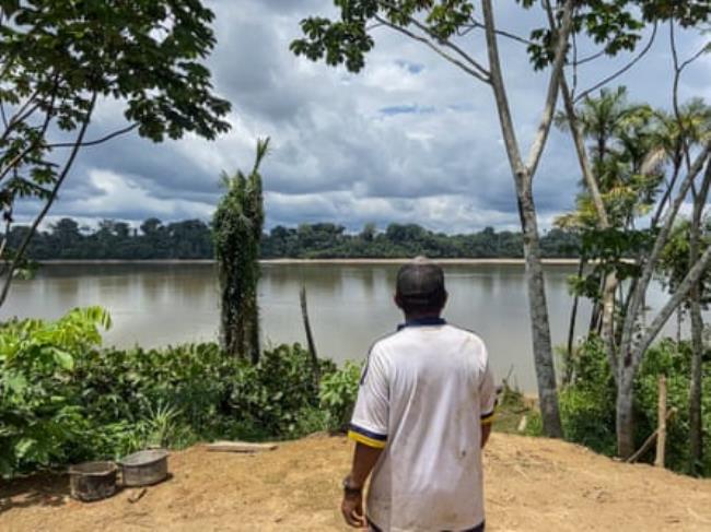 A man looks across a body of water. 
