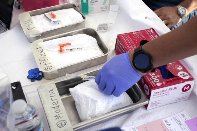 FILE - Syringes with vaccines are prepared at the L.A. Care and Blue Shield of California Promise Health Plans' Community Resource Center where they were offering members and the public free flu and COVID-19 vaccines Oct. 28, 2022, in Lynwood, Calif. Updated COVID-19 vaccines are expected in the latter half of 2023 — just in time to pair them with flu shots. (AP Photo/Mark J. Terrill, File)